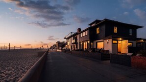 Un hotel frente al mar con un paseo marítimo, acceso directo a la playa y una hilera de edificios con terrazas.