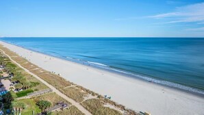 A beach with a clear sky, sandy shore, and a few people. - Honeymoon Suite with Direct Oceanfront View,Pools! (Myrtle Beach)