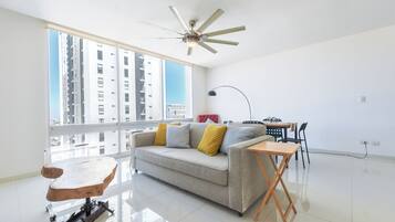 Uma sala de estar ampla com sofá, mesa de centro e área de jantar com cadeiras.