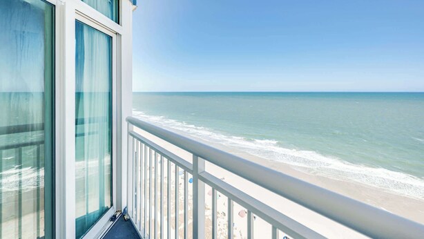 Un balcone con vista sull'oceano e sulla spiaggia.
