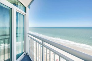 Un balcon avec vue sur l’océan et la plage.
