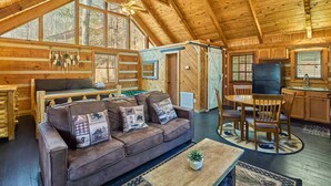 A cozy log cabin interior with a living room, dining area, and kitchen. - Peace, Quiet, and a Cozy Cabin (Sevierville)
