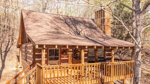 A wooden cabin with a balcony, surrounded by trees. - Peace, Quiet, and a Cozy Cabin (Sevierville)