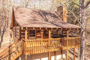 A wooden cabin with a balcony, surrounded by trees. - Peace, Quiet, and a Cozy Cabin (Sevierville)