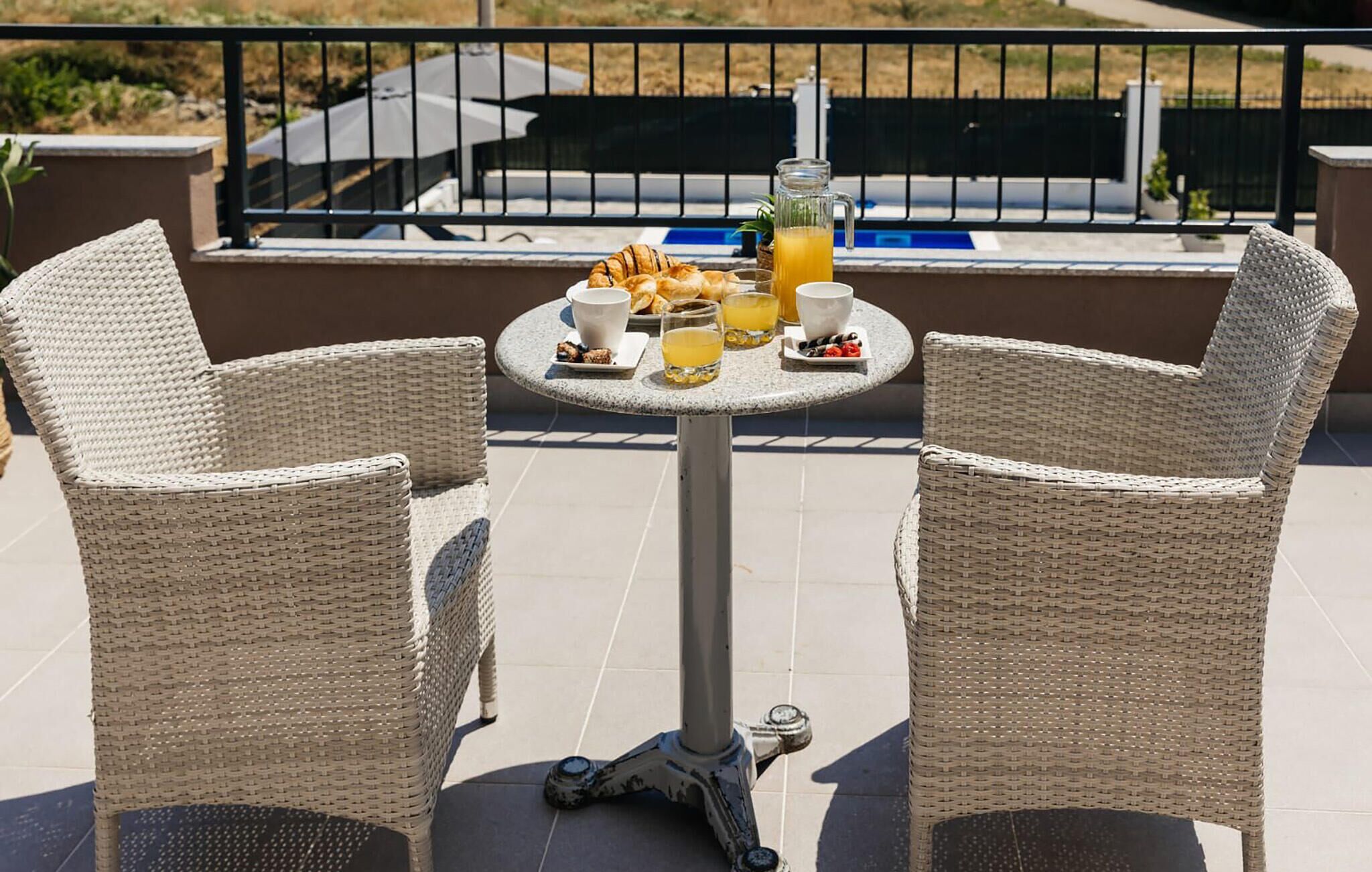 Una mesa con alimentos y bebidas en un balcón.