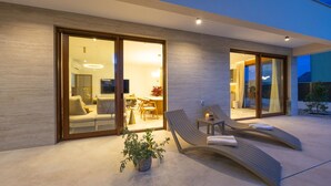 Ein moderner Außenbereich mit einer Couch, Lounge-Stühlen und einem Esstisch.