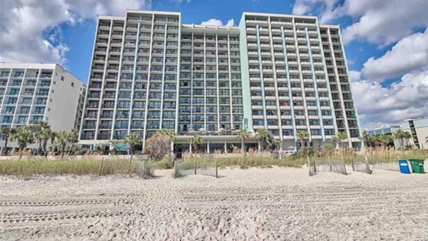 A multi-story hotel with a modern design, featuring a large number of balconies and a central courtyard. - 1BR Compass Cove Oceanfront, Heated Pools, Updated (Myrtle Beach)