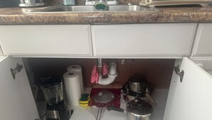 Une cuisine équipée d’un évier, d’un plan de travail et de placards.