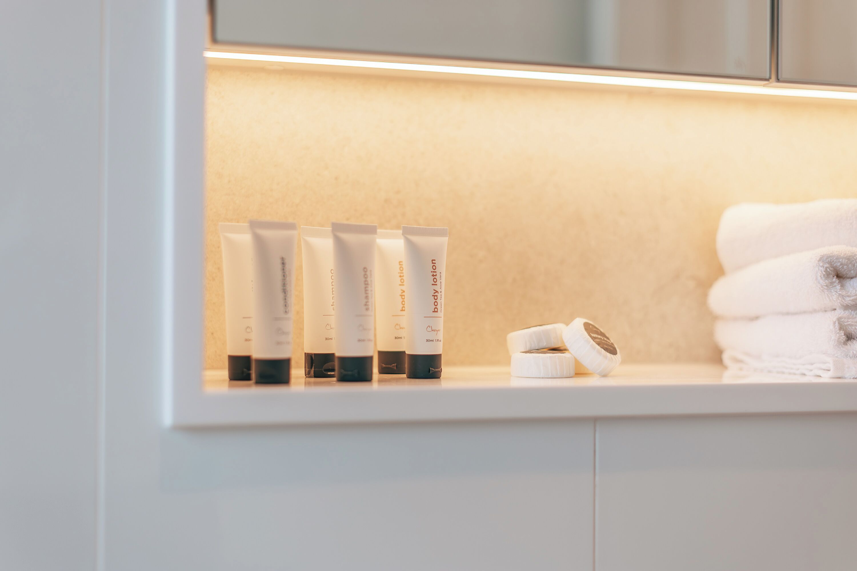 Une étagère avec des produits de soins pour la peau et un rouleau de ruban adhésif.