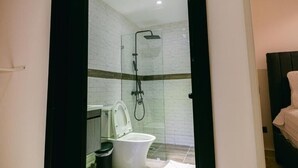 Un baño moderno con ducha de vidrio, inodoro y lavamanos.