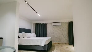 A modern bedroom with a bed, a glass table, and a marble floor. - Habitacion Deluxe cama extragrande A-204 (Punta Cana)