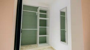 A room with a green wall, white shelving unit, and a window. - Habitacion Deluxe cama extragrande A-204 (Punta Cana)