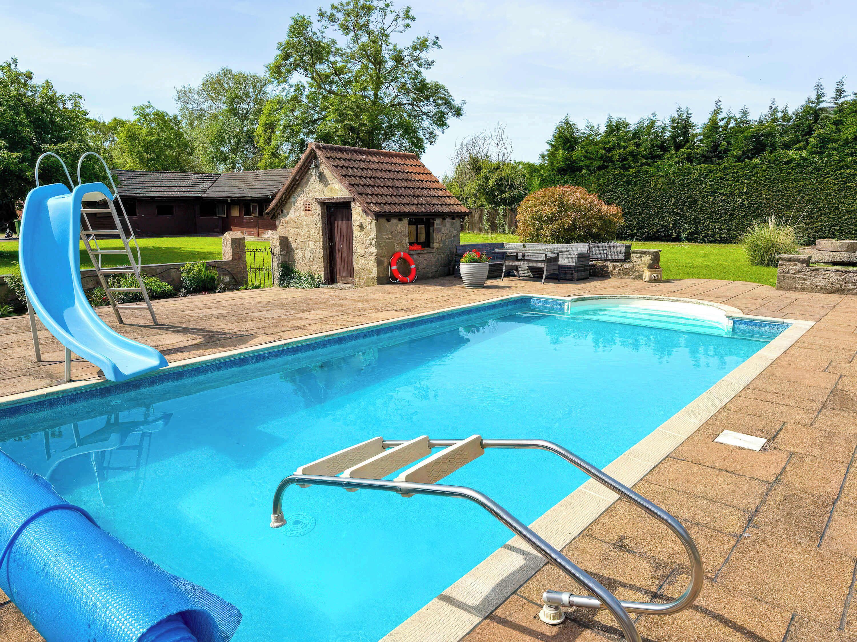 Une piscine avec un toboggan, une échelle et une bouée de sauvetage.