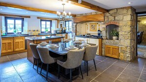 A spacious kitchen with a large island, stone accents, and a built-in oven. - Exceptional Luxury at Laurel House by STAE-Homes (Magor)