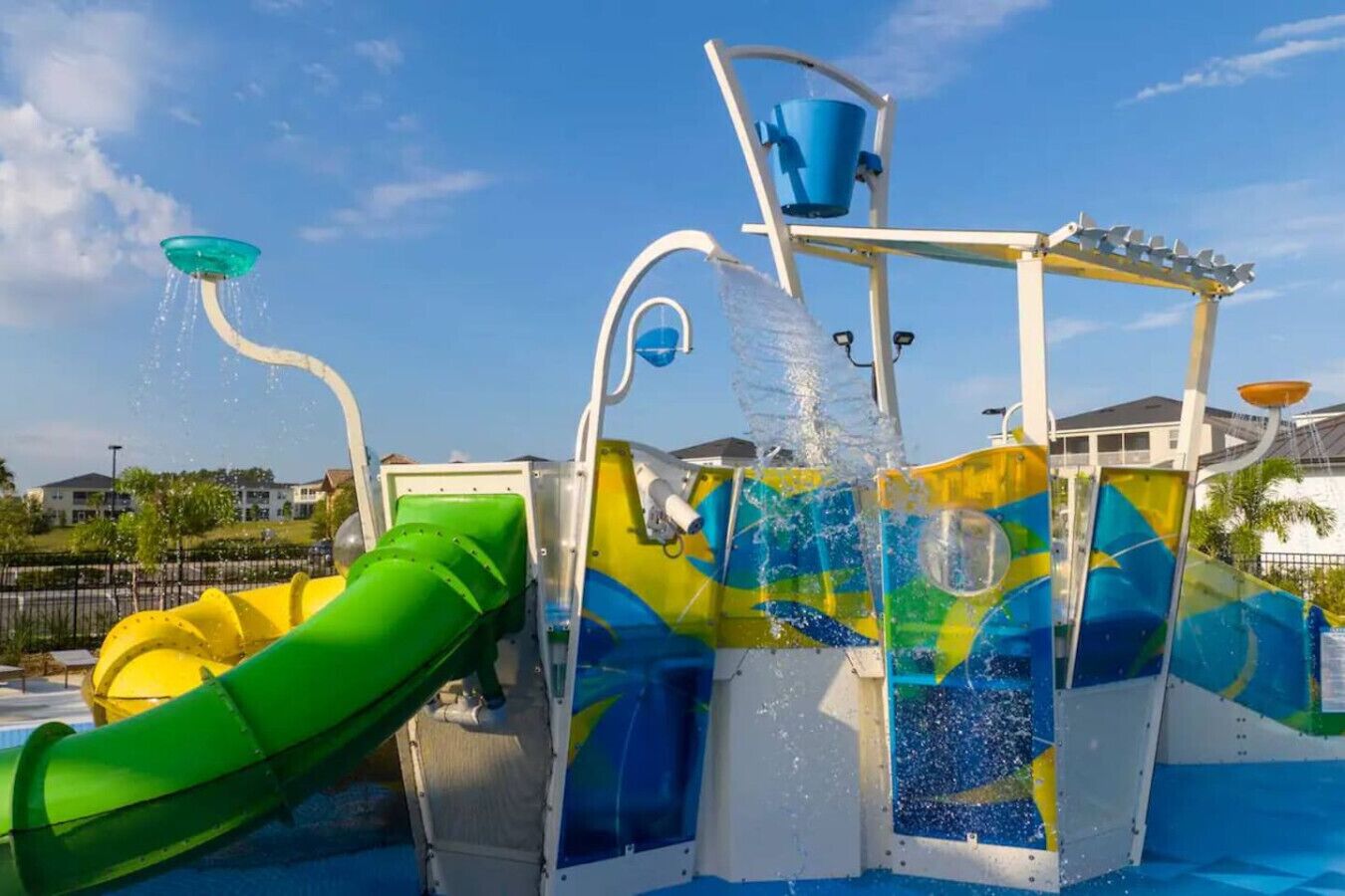 A water play area with a green slide and multiple water jets.