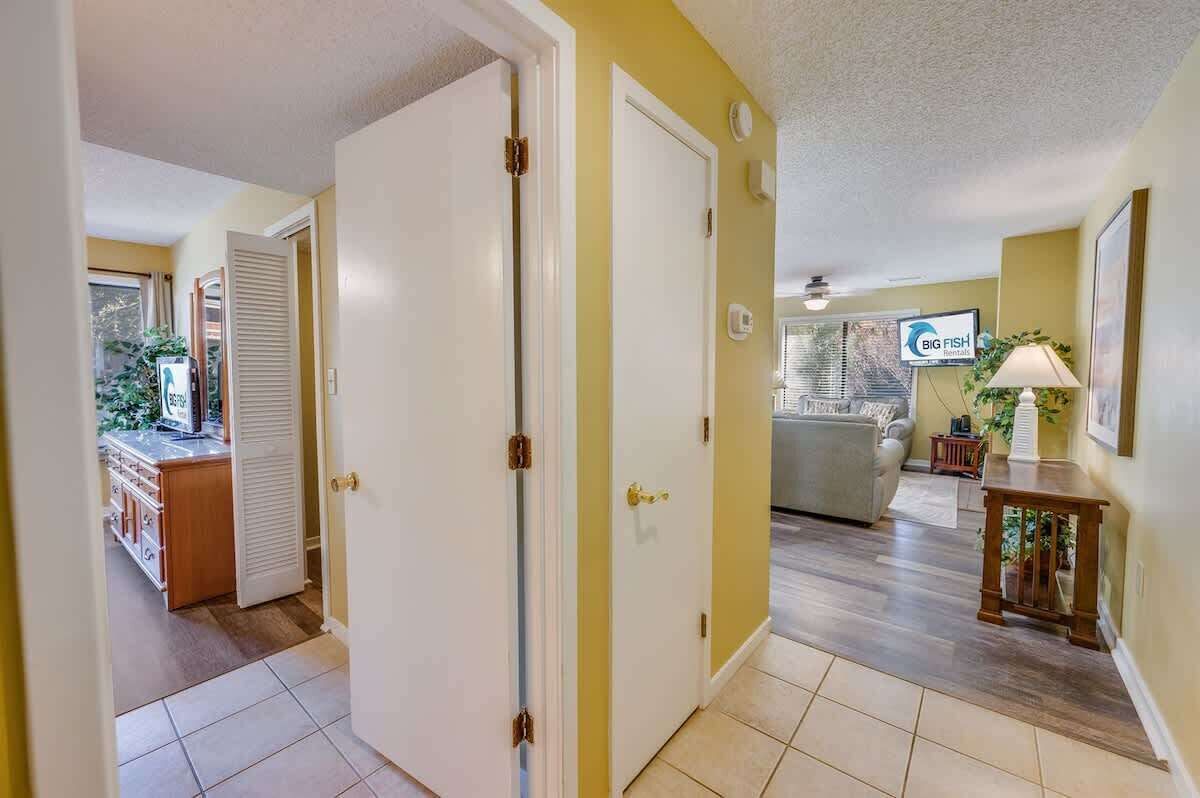 A hallway with a kitchen area, a dining area, and a living room.