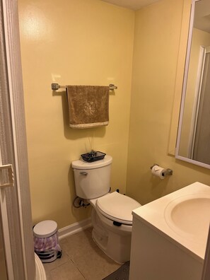 Ein kleines Badezimmer mit Toilette, Waschbecken und einem Handtuch an einem Haken.