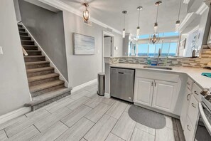 A modern kitchen with a central island, stainless steel appliances, and pendant lighting. - Luxury 2 Story Oceanfront Penthouse at the  Palms (Myrtle Beach)