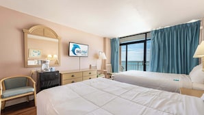 Ein Hotelzimmer mit zwei Betten, einem Schreibtisch, einem Stuhl, einem Spiegel, einem Fenster mit Vorhängen und einem Schild für Big Fish Rentals.