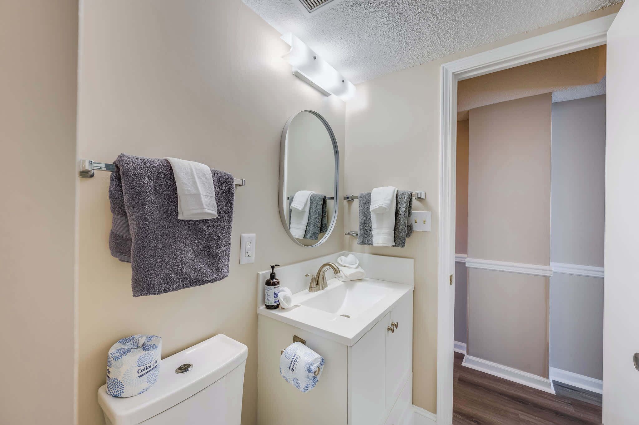 Une salle de bain équipée d’un WC, d’un lavabo, d’un miroir et d’un porte-serviettes.