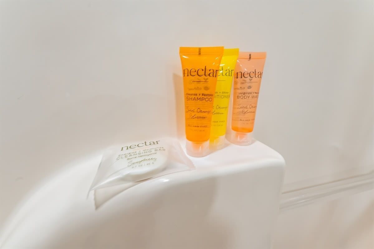 Three tubes of Nectar body wash on a white surface.