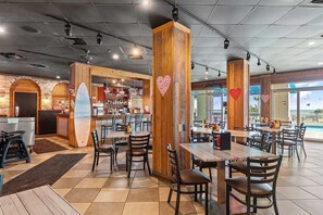 Een restaurant met houten inrichting, een bar en uitzicht op de oceaan.
