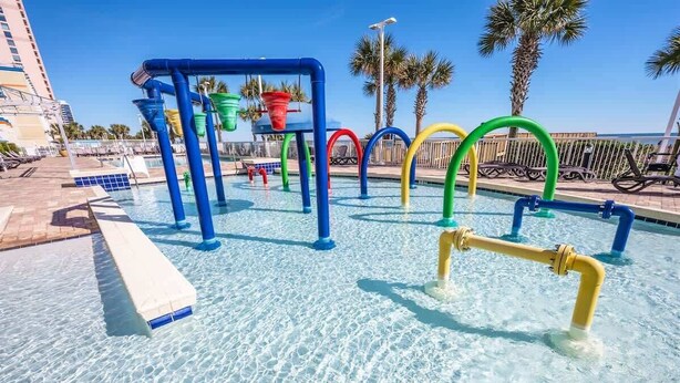 A swimming pool with colorful water slides and a clear blue sky.