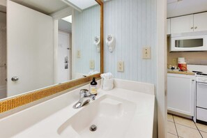 A bathroom with a large mirror, a white sink, and a towel. - New Direct Oceanfront 8th  Floor, Sandcastle South (Myrtle Beach)