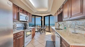 Uma cozinha com vista para o oceano, um espaço de refeições e uma ilha grande.