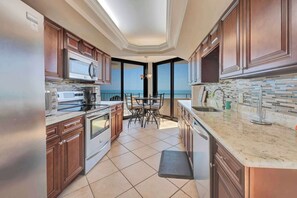 A kitchen with a view of the ocean, a dining area, and a large island. - 2BR Remodeled Oceanview in Private Maisons Sur Mer (Myrtle Beach)