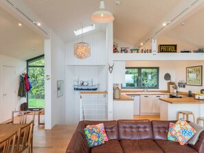 A modern kitchen with a 'Patrol' sign, a hanging light fixture, and a ship decoration on the wall. - Green Shutters (Pembroke)