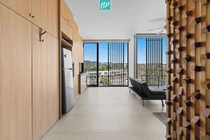Eine moderne Wohnung mit Küche, einem Balkon mit Aussicht und einer Wandverkleidung aus Holz.