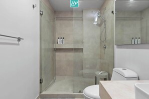 Une salle de bain moderne avec une douche à parois de verre, des toilettes et un lavabo.