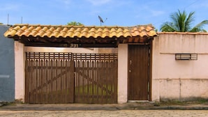 A gated entrance with a tiled roof, a hexagonal tile pavement, and a number "331" on the gate. - Casa com Piscina e rea Gourmet em Boi Ucanga (São Sebastião)