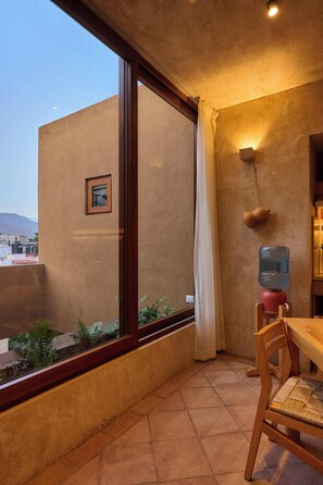 A room with a large window, a water dispenser, a wooden chair, and a small picture on the wall. - Casona Xochimilco - Xochimilco (Oaxaca de Juárez)