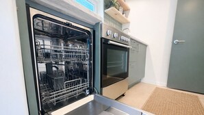 Una cucina con lavastoviglie, forno e una porta con serratura a chiave.