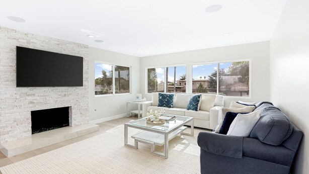 A modern living room with a fireplace, a flat-screen TV, a sofa, and a coffee table. - Seal Beach Escape by Avantstay Modern Home + Fireplace Prvte Courtyard + Walk to Beach + Dining (Seal Beach)