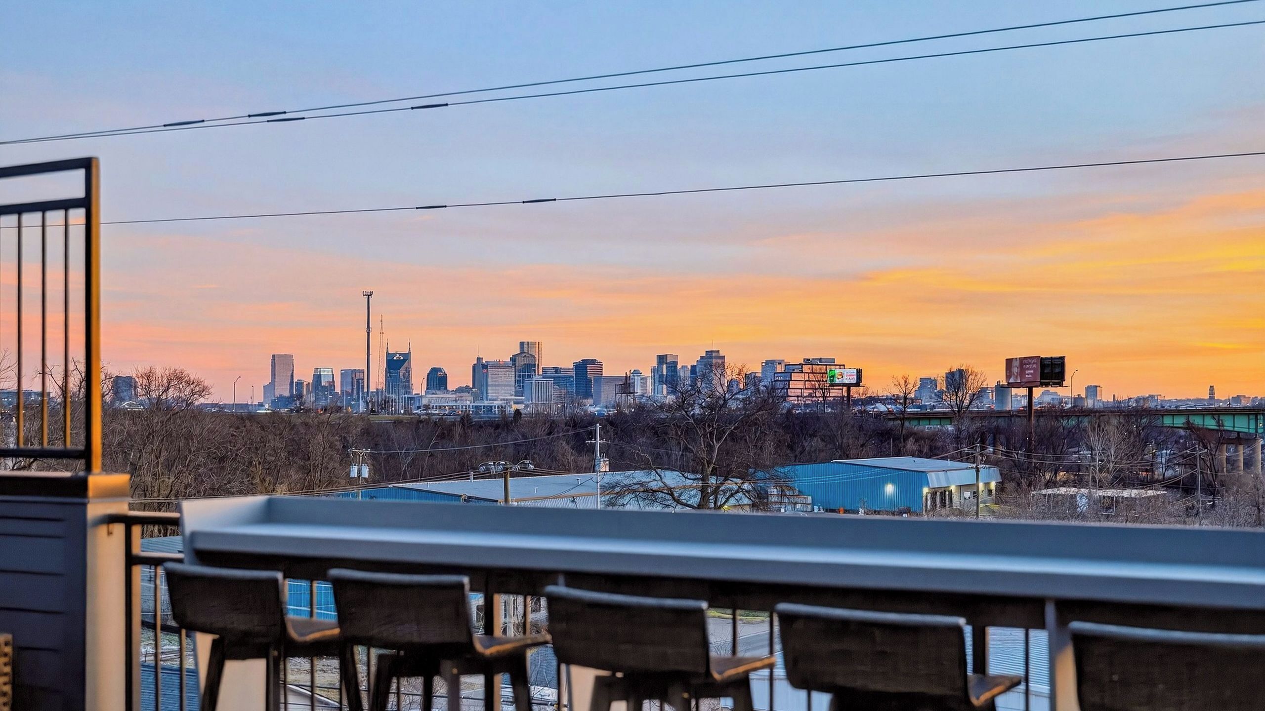 Ein Stadtpanorama im Abendlicht mit Blick auf Gebäude und eine Brücke.