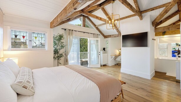 A bedroom with a large bed, a desk, and a balcony. - Venice Veranda by Avantstay 3-min Walk to Beach + Rare Walk Street EV Charger + Firepit + Outdoor Dining (Venice)