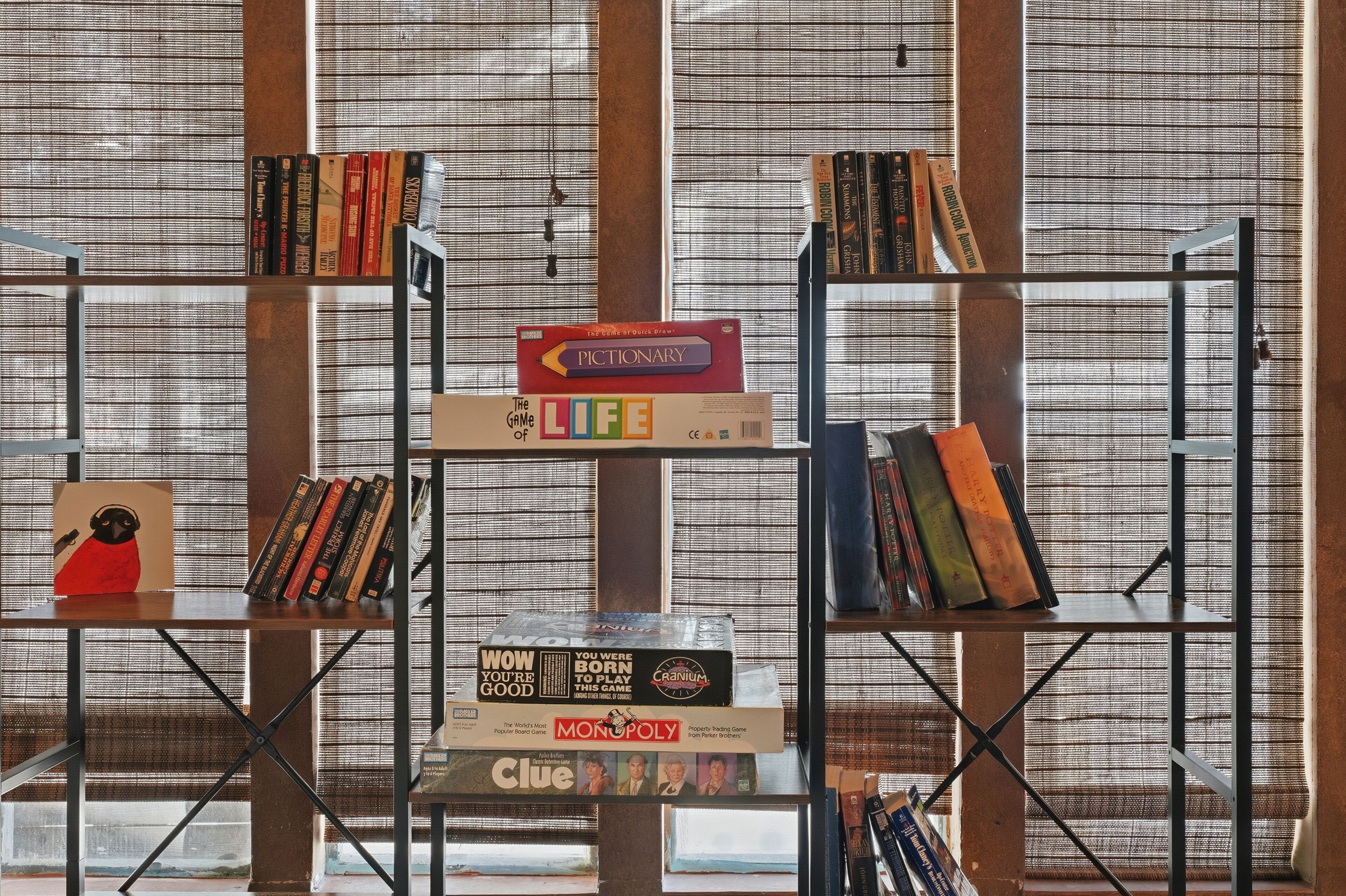 Une pièce avec une bibliothèque contenant divers jeux de société et livres.