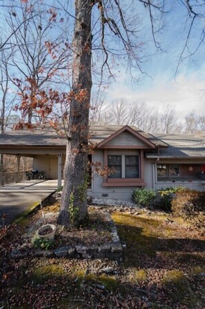 A two-story house with a covered porch and a small front yard. - Treehouse Vibes near Lake Coronado (Hot Springs)