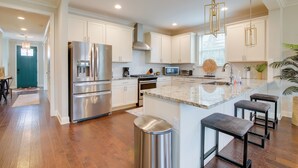 A modern kitchen with white cabinets, stainless steel appliances, and a marble countertop. - Pool Table! Walkable Stay in Midtown MEM (Memphis)