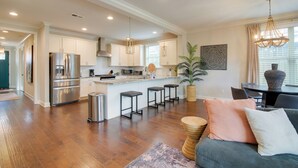 A spacious kitchen with stainless steel appliances, a central island with stools, and pendant lighting. - Pool Table! Walkable Stay in Midtown MEM (Memphis)