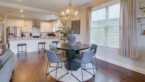 A modern kitchen with a central island, a dining area with a round table and chairs, and a large window with curtains. - Pool Table! Walkable Stay in Midtown MEM (Memphis)