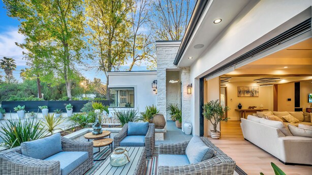 A modern outdoor living area with wicker furniture, a coffee table, and potted plants. - private resort excusive villa Tarzana south 6500sq with adu pool spa (Los Angeles)