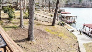 A lakeside property with a wooden deck, a dock, and a small house. - 05202 - 3 Guadalajara Lane (Hot Springs Village)