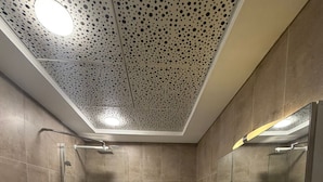 Moderni kylpyhuone, jossa on suihku, wc, kylpyamme ja pesuallas.