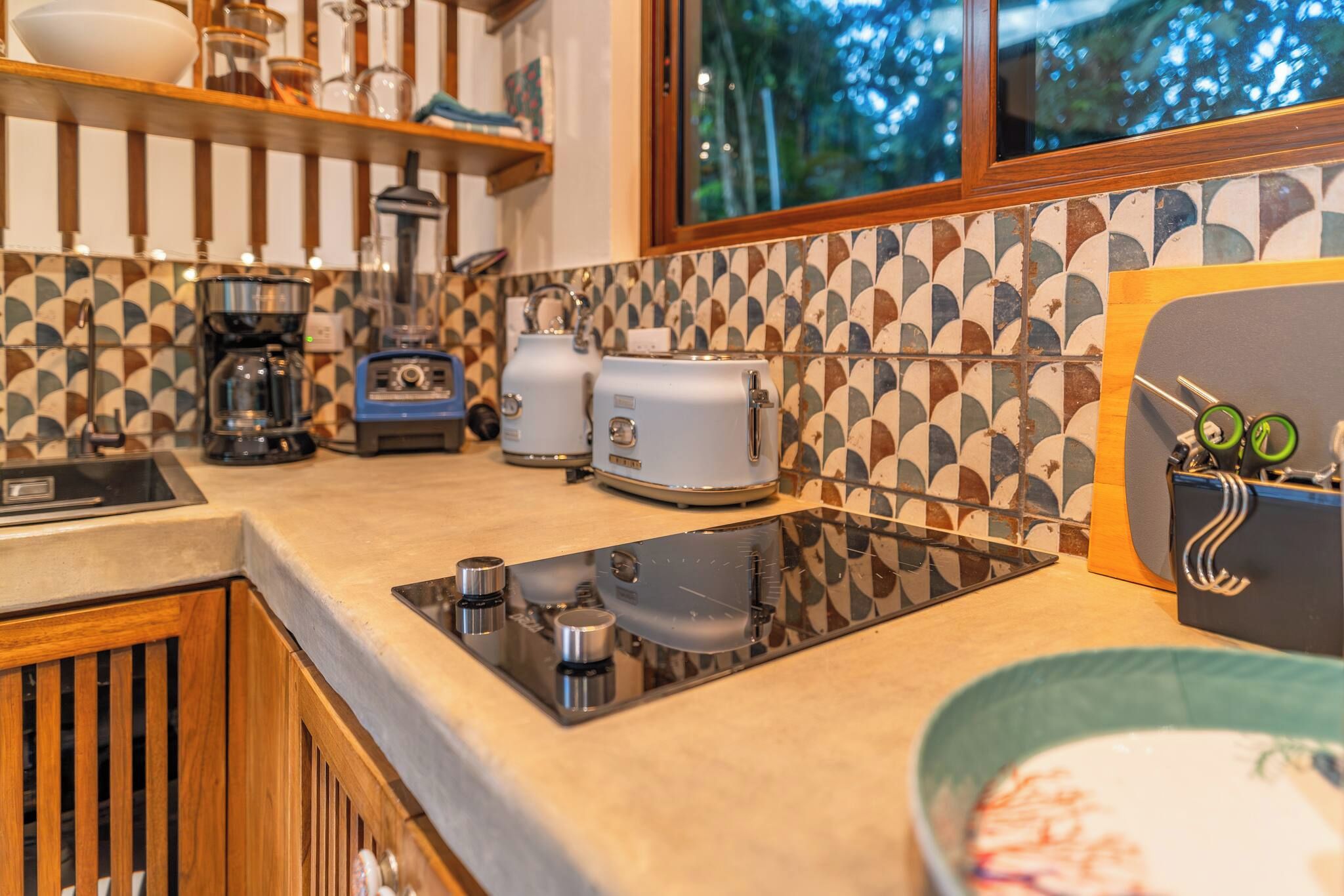 A kitchen with a modern design, including a built-in stove, a coffee maker, and a toaster.