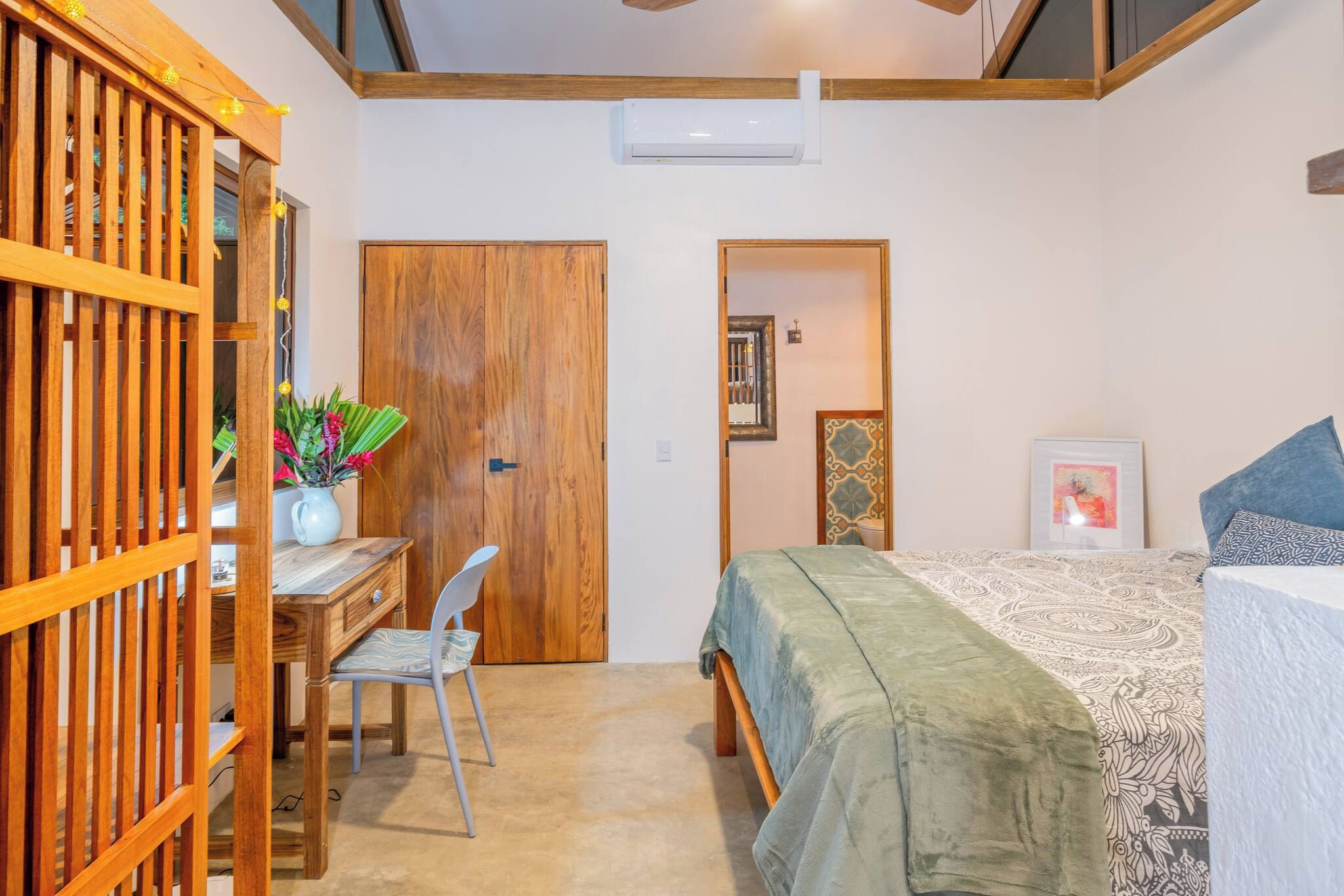 Ein Schlafzimmer mit einem Bett, einem Schreibtisch, einem Stuhl und einem Kleiderschrank.