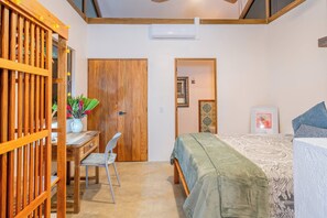 Ein Schlafzimmer mit einem Bett, einem Schreibtisch, einem Stuhl und einem Kleiderschrank.